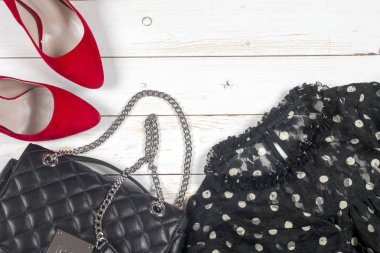 Kadın giyim ayarla ve aksesuarları üzerinde ahşap arka plan beyaz.