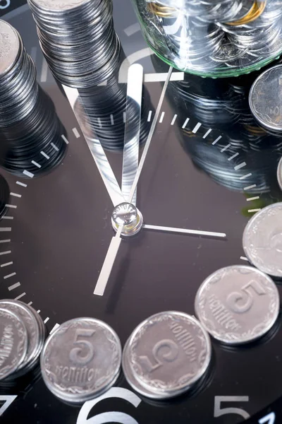 Münzen mit Pflanze und Uhr, isoliert auf weißem Hintergrund. — Stockfoto