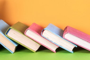 Parlak renkli arka plan üzerinde renkli kitap seti. Okula dönüş