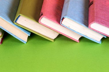 Parlak renkli arka plan üzerinde renkli kitap seti. Okula dönüş