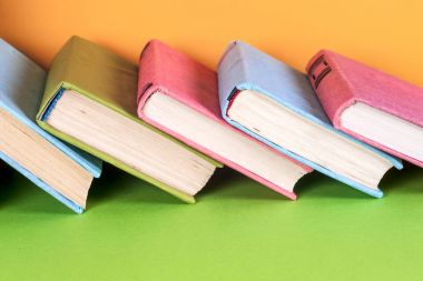 Parlak renkli arka plan üzerinde renkli kitap seti. Okula dönüş