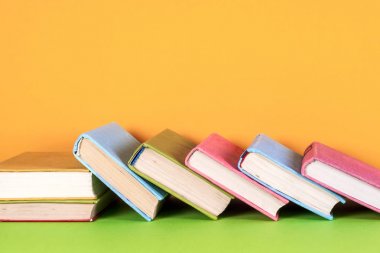 Parlak renkli arka plan üzerinde renkli kitap seti. Okula dönüş