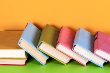 Parlak renkli arka plan üzerinde renkli kitap seti. Okula dönüş