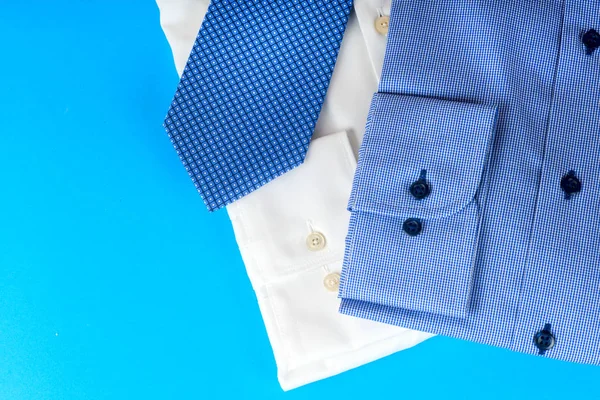 Empilement de chemise bleue et blanche gros plan sur un fond clair . — Photo
