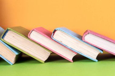 Parlak renkli arka plan üzerinde renkli kitap seti. Okula dönüş