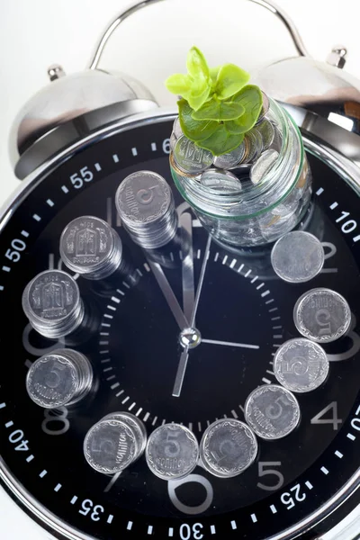 Monedas con planta y reloj, aisladas sobre fondo blanco . — Foto de Stock