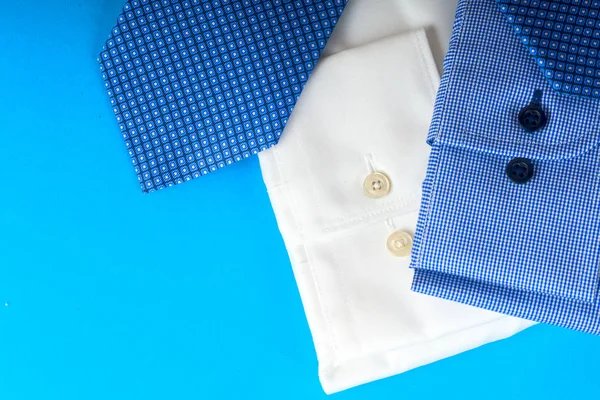 Pilha de azul e branco camisa closeup em um fundo leve . — Fotografia de Stock