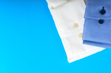 Mavi ve beyaz gömlek closeup hafif bir arka plan üzerinde yığını.