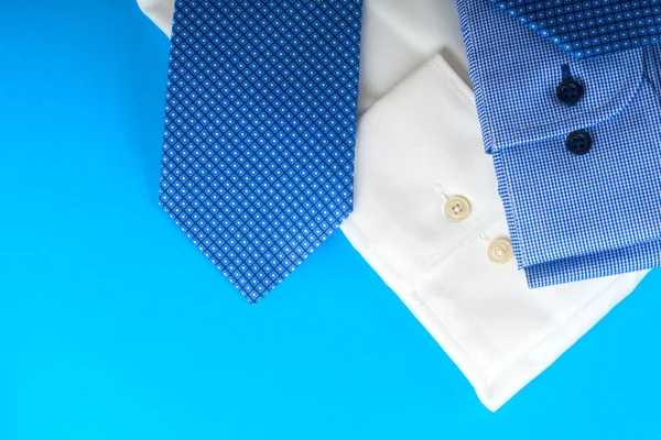 Empilement de chemise bleue et blanche gros plan sur un fond clair . — Photo