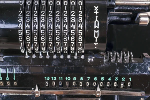 Old rusty retro calculator black standing on a wooden table