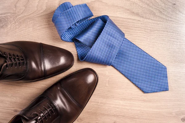 Mens accessories mens shoes, tie on a wooden background. Classic mens accessories. Top view