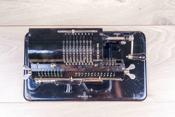 Old rusty retro calculator black standing on a wooden table