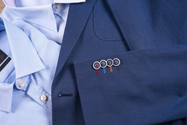 Klasik erkek kıyafetleri - mavi takım, gömlekler, kahverengi ayakkabılar, kemer ve kravat ahşap arka planda.