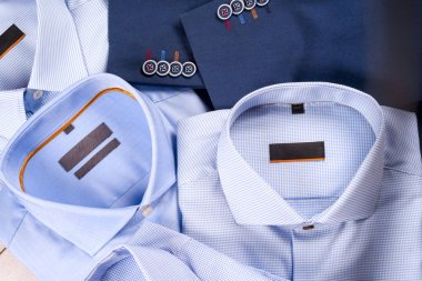 Düz ahşap zemin üzerine mavi takım elbise, gömlek, kahverengi ayakkabı, kemer ve kravat gibi klasik erkek giysi set koymak.