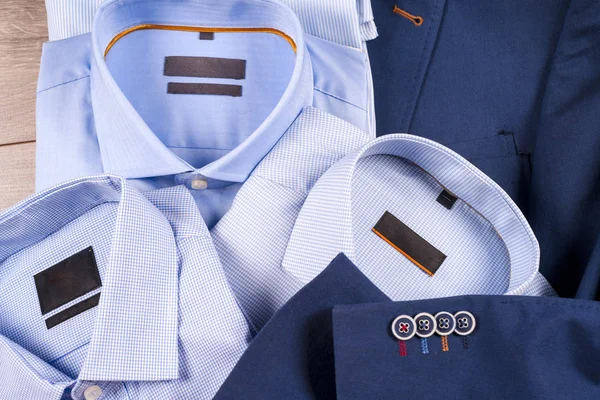 Klasik erkek kıyafetleri - mavi takım, gömlekler, kahverengi ayakkabılar, kemer ve kravat ahşap arka planda.