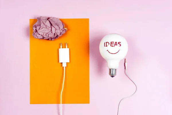 Grande ideia conceito com papel colorido amassado e lâmpada no fundo de luz — Fotografia de Stock