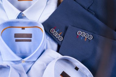 Klasik erkek kıyafetleri - mavi takım, gömlekler, kahverengi ayakkabılar, kemer ve kravat ahşap arka planda.