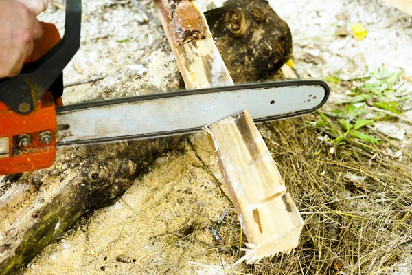 Sawing wood with a chainsaw.