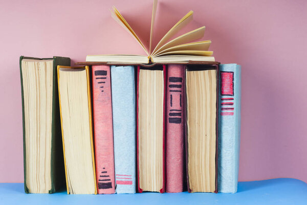 Open book, hardback books on bright colorful background.