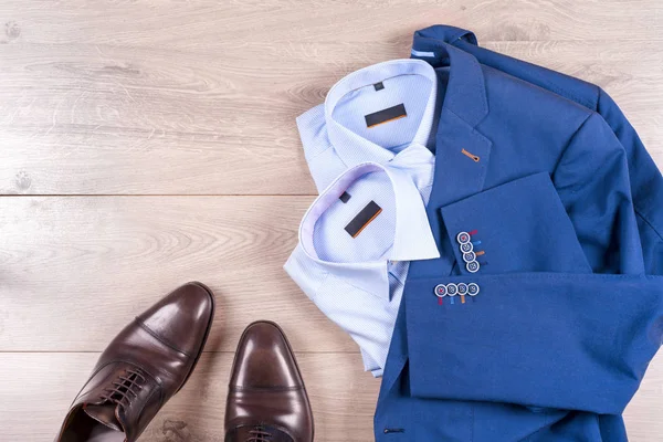Klasik erkek kıyafetleri - mavi takım, gömlekler, kahverengi ayakkabılar, kemer ve kravat ahşap arka planda. — Stok fotoğraf