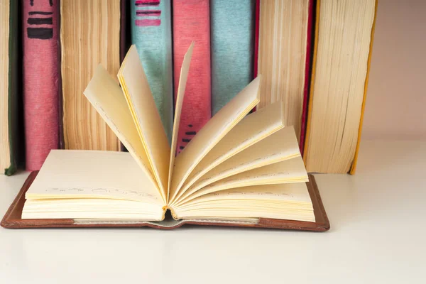 Öppen bok, inbundna böcker på ljusa färgglada bakgrund. — Stockfoto