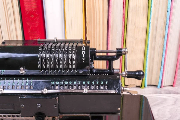 Old rusty retro calculator black standing on a wooden table