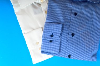 Mavi ve beyaz gömlek closeup hafif bir arka plan üzerinde yığını.