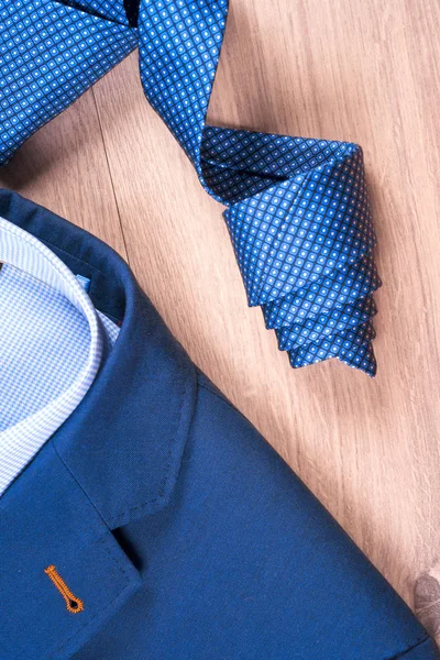 Ensemble de vêtements classiques pour hommes costume bleu, chemises, chaussures brunes, ceinture et cravate sur fond en bois. — Photo