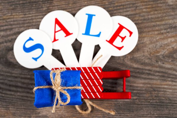 Рождественская распродажа. Красные сани полны подарочных коробок
