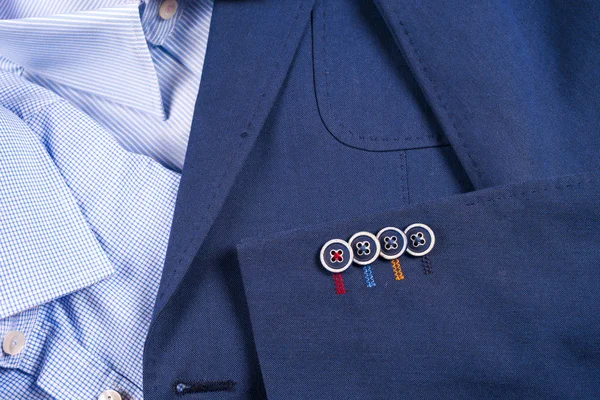 set of classic mens clothes - blue suit, shirts, brown shoes, belt and tie on wooden background.