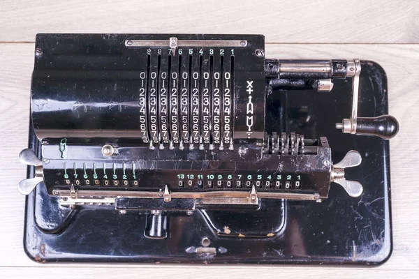 Calculadora retro enferrujado velho preto de pé em uma mesa de madeira — Fotografia de Stock