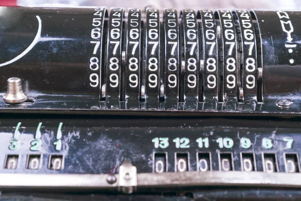 Old rusty retro calculator black standing on a wooden table