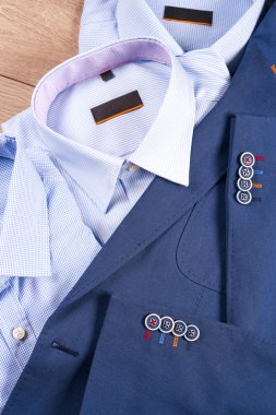 Klasik erkek kıyafetleri - mavi takım, gömlekler, kahverengi ayakkabılar, kemer ve kravat ahşap arka planda.