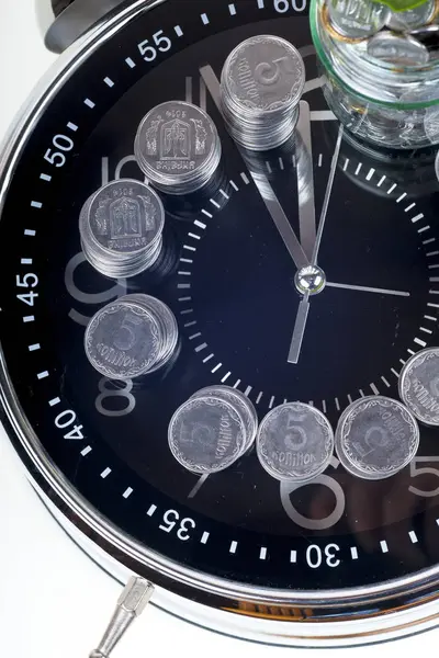 Монети з рослиною і годинником, ізольовані на білому тлі. концепція заощаджень — стокове фото
