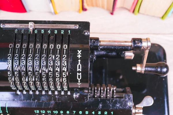 Old rusty retro calculator black standing on a wooden table