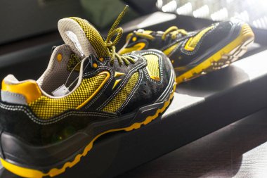 Spor salonunda UNBRANDED modern spor ayakkabı. Siyah-Sarı. Rahat ayakkabılar.