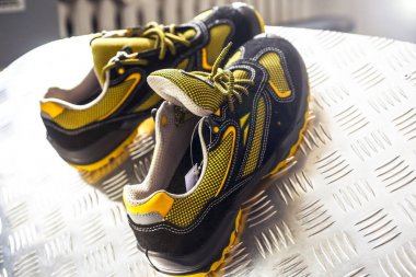 Spor salonunda UNBRANDED modern spor ayakkabı. Siyah-Sarı. Rahat ayakkabılar.