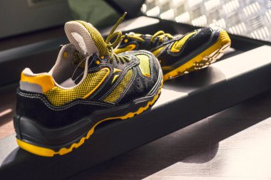 Spor salonunda UNBRANDED modern spor ayakkabı. Siyah-Sarı. Rahat ayakkabılar.