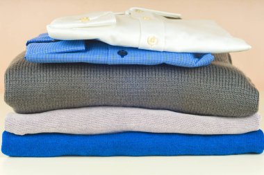 Mavi ve beyaz gömlek closeup hafif bir arka plan üzerinde yığını.