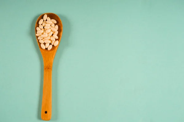 Ξύλινο κουτάλι με μια μεζούρα σε μπλε φόντο, διατροφή, υγιεινό τρόπο ζωής. — Φωτογραφία Αρχείου
