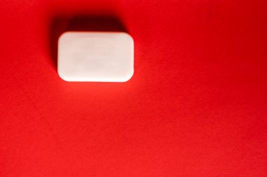 Ortasında kopya alanı olan köpüklü sabun çubuğu parlak kırmızı arkaplanda izole edildi.