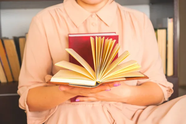 Fiatal lány könnyű ruhában könyvet olvas. A női kezek könyvet tartanak a kezükben. — Stock Fotó