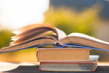 Doğal arka planda tahta masa üzerine açık bir kitap. Yumuşak odak