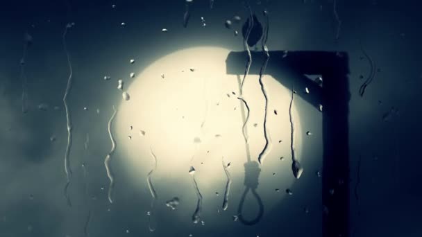 Corvo nero in piedi su una forca con un'oca attraverso un vetro con gocce di pioggia — Video Stock