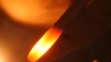 Bir demirci örs üzerinde sıcak Metal çekiçle vurarak başlar