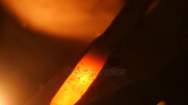 Le forgeron frappe le métal chaud avec un marteau sur une enclume au ralenti 