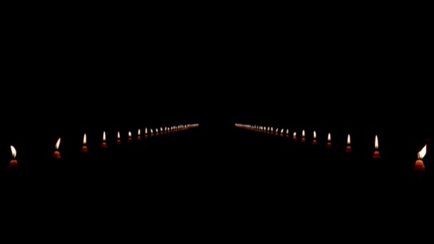 Um caminho de velas iluminadas em um fundo preto — Vídeo de Stock