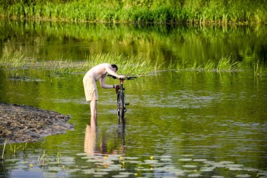 Adam nehre Snov Bisiklet yıkar