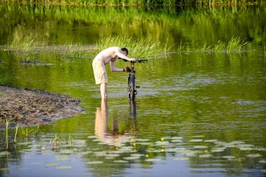 Adam nehre Snov Bisiklet yıkar