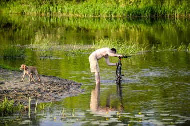 Adam nehre Snov Bisiklet yıkar
